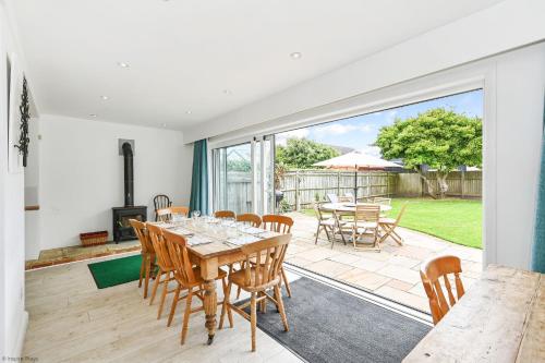 a dining room with a table and chairs and a patio at Marine House by inspirestays-com in East Wittering