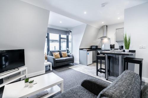 a living room with a couch and a kitchen at K Suites - Colne House in Lowestoft