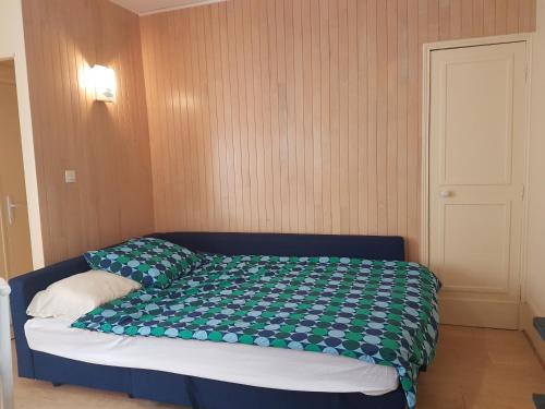 - une chambre avec un lit et une couette verte et blanche dans l'établissement Studio près de la tour Eiffel, à Paris