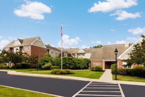 una casa con una bandera americana en una calle en Residence Inn Boston Foxborough, en Foxborough