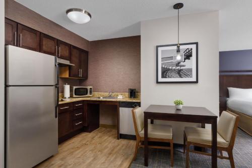 a kitchen and dining room with a refrigerator and a table at Residence Inn by Marriott Boston Foxborough in Foxborough
