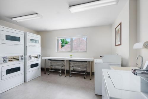 a kitchen with white appliances and a table at Residence Inn by Marriott Boston Foxborough in Foxborough