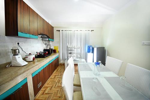 a kitchen with a white table and white chairs at Green Hill Apartment Kathmandu in Kathmandu