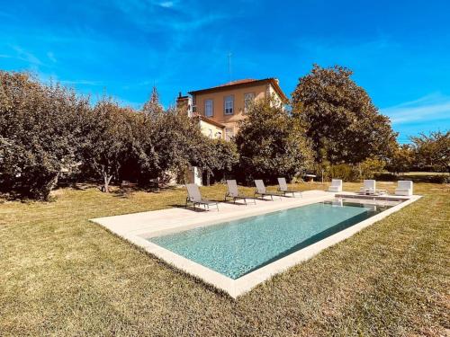 a swimming pool with chairs and a house at Quinta Tilia - Farmhouse in Oliveira de Azemeis