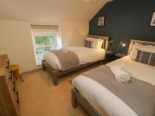 sypialnia z 2 łóżkami i oknem w obiekcie Flora Cottage w mieście Buxton