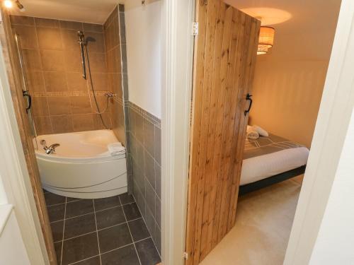 a bathroom with a tub and a toilet and a sink at Flora Cottage in Buxton