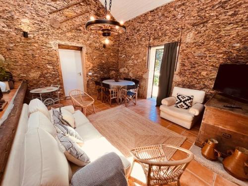 a living room with a white couch and a brick wall at Quinta Tilia - Farmhouse in Oliveira de Azemeis
