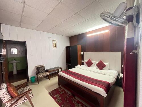 een slaapkamer met een bed en een stoel erin bij Hotel Amar in Mussoorie