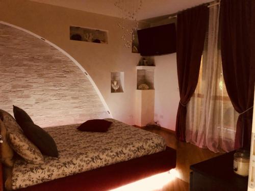 a bedroom with a bed and a brick wall at Serendipity in Bentivoglio