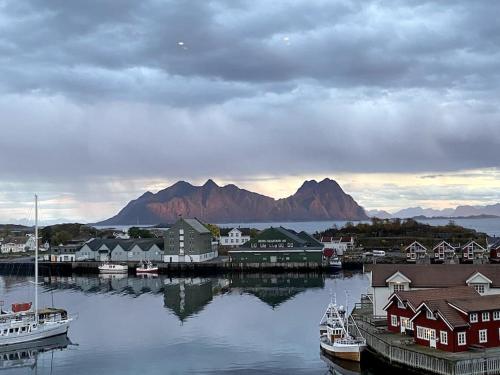 a harbor with boats in the water with mountains in the background at Jaw dropping New Penthouse apt in Svolvær in Svolvær