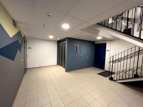 an empty hallway with a blue door and a staircase at Jaw dropping New Penthouse apt in Svolvær in Svolvær