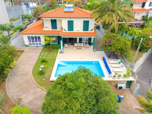 - une vue aérienne sur une maison avec une piscine dans l'établissement VILLA LEONARDO, à Caniço