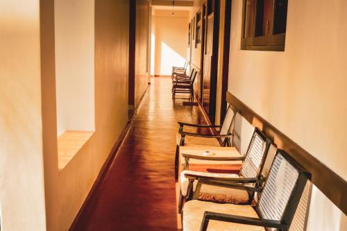 a corridor with chairs and tables in a hallway at Sunny Lanka Guest House in Matara