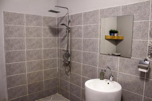 a bathroom with a shower with a sink and a mirror at R34 Boutique Guest House in Veliko Tŭrnovo