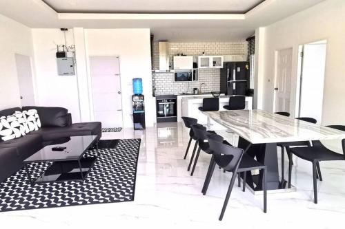 a dining room and living room with a table and chairs at BaanKuer Hill Pool Villa in Ko Lanta