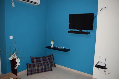 Habitación azul con TV en una pared azul en Πολυτελές Διαμέρισμα με Θέα en Sparti