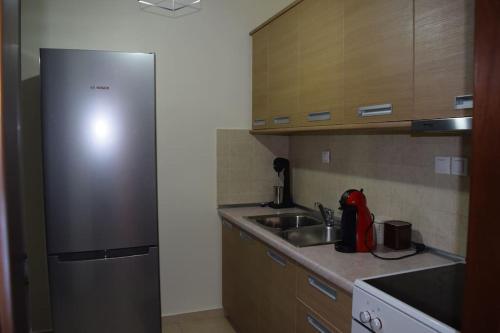 a kitchen with a stainless steel refrigerator and a sink at Πολυτελές Διαμέρισμα με Θέα in Sparta