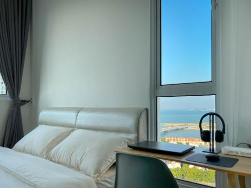 um quarto com uma cama, uma secretária e uma janela em Seaview Private Master Bedroom in a Shared Unit em Tanjong Tokong
