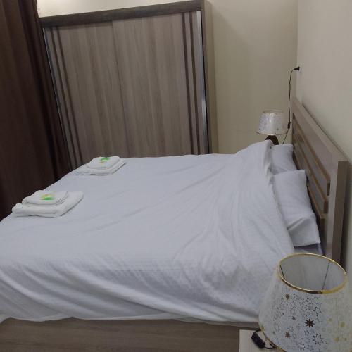 a white bed with two towels on top of it at Dream house hotel jerash in Jerash