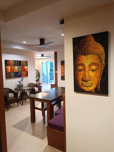 a dining room with a painting of a head on the wall at Khanom Beach Residence Monthly Rental Condo in Khanom