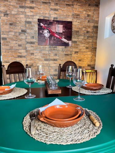 a table with an orange plate and wine glasses at Vespa House in Igrejinha