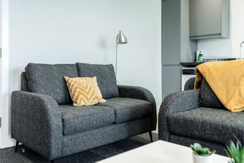 a couch and a chair in a living room at K Suites - Colne House in Lowestoft