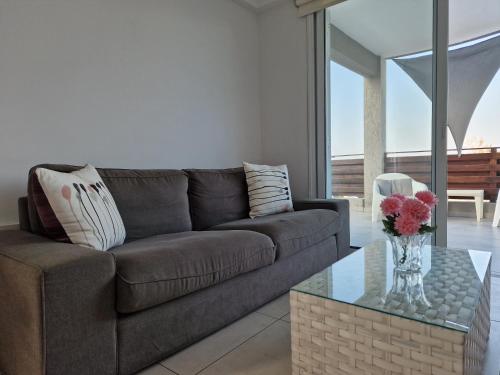 a living room with a couch and a table at Kalifi Pool Apartment in Paralimni