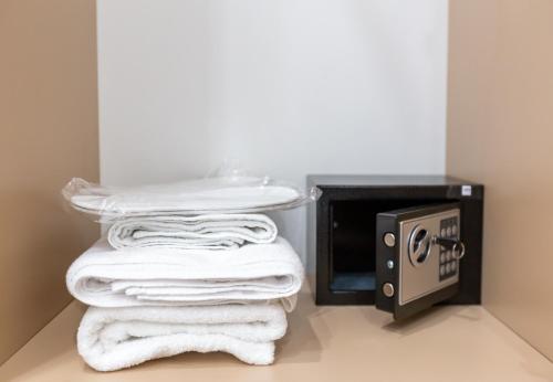 a pile of towels sitting next to a toaster oven at Hillside City Center Hotel in Baku