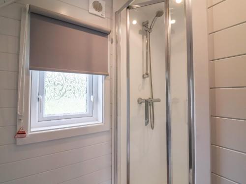 a shower in a bathroom with a window at Hare's Hollow in Skipton