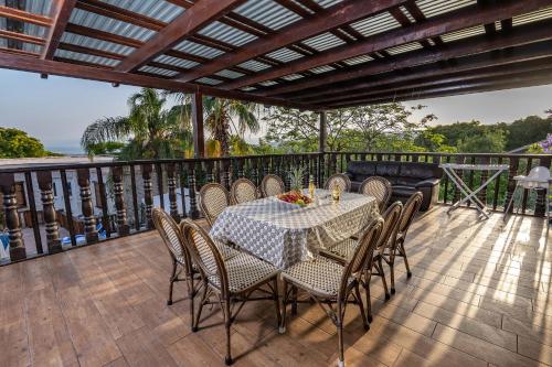 a table and chairs on a balcony with a view of the ocean at The Pearl of the Golan - Pnina BaGolan in Had Nes