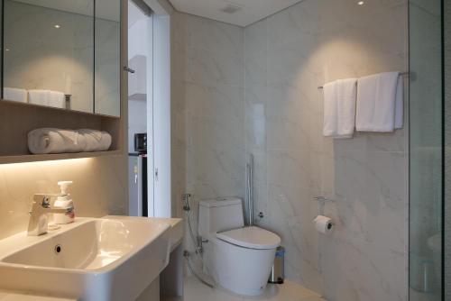 a bathroom with a toilet and a sink and a shower at Cassia Residences 1 in Bang Tao Beach