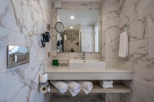 een witte badkamer met een wastafel en een spiegel bij Benata Beach Hotel Ultra All Inclusive in Manavgat