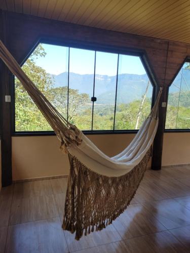 uma rede de descanso num quarto com janelas grandes em Alvorada Mountain - 1 em Praia Grande