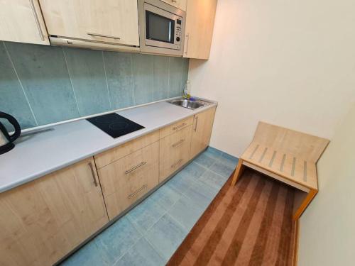 eine Küche mit Holzschränken, einer Mikrowelle und einer Bank in der Unterkunft Fantastic - Z6 Room - 403A in Warschau