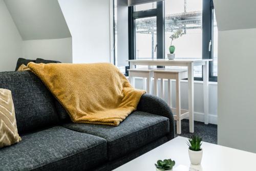 a living room with a couch and a table at K Suites - Colne House in Lowestoft
