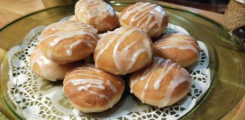 a pile of donuts on a glass plate on a table at Tawerna Rataje Pokoje Gościnne in Chodzież