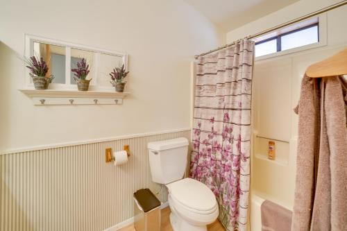 a bathroom with a toilet and a window at Hikers Haven Pine Getaway with Wraparound Deck! in Pine