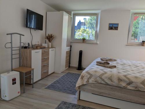 a bedroom with a bed and a dresser and windows at Hygge Apartment in Warstein