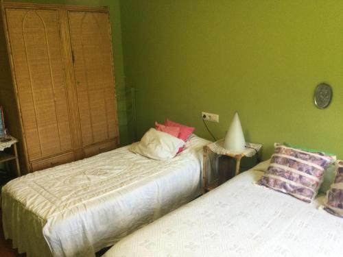 twee bedden in een kamer met groene muren bij Habitación en A Armenteira ideal peregrinos in Meis