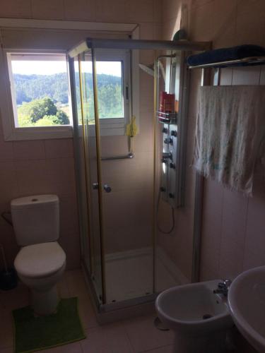 een badkamer met een douche, een toilet en een wastafel bij Habitación en A Armenteira ideal peregrinos in Meis