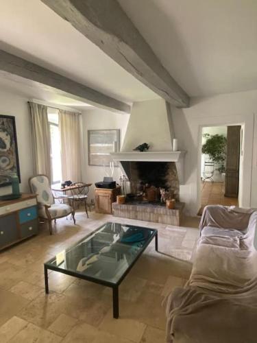 - un salon avec une table en verre et une cheminée dans l'établissement Villa provençale familiale avec piscine, à Grimaud