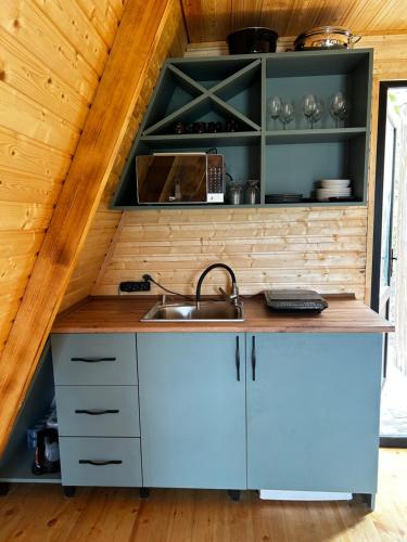 a kitchen with white cabinets and a sink at HillSide Cottage in Keda