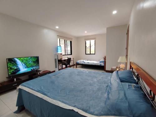 um quarto com uma cama grande e uma televisão de ecrã plano em Studio Room Casa Loreto near Ayala Center Cebu em Cebu