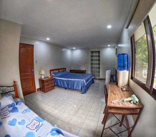 een slaapkamer met een bed, een tafel en een bureau bij Studio Room Casa Loreto near Ayala Center Cebu in Cebu City