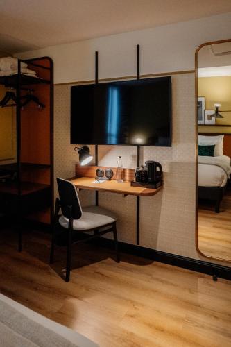 a room with a desk and a bed and a mirror at Hôtel Riesner in Paris