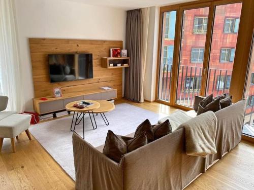 uma sala de estar com um sofá e uma mesa em Luxury Mountain Hotel Apartment em Andermatt