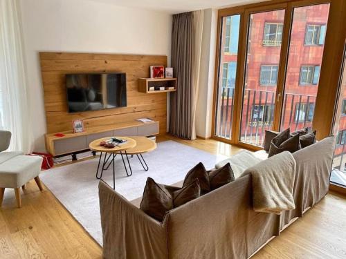 a living room with a couch and a table at Luxury Mountain Hotel Apartment in Andermatt