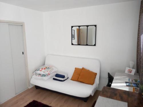 un divano bianco in soggiorno con specchio di Le Zen -studio tout équipé- WIFI Fibre-centre ville a Tarbes