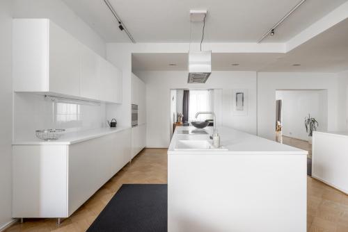 una cucina con armadi bianchi e lavandino di Elegant City Home a Helsinki