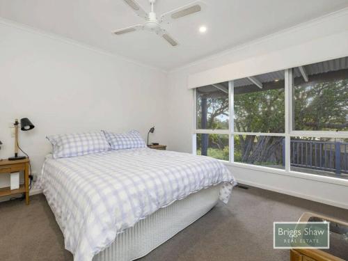 um quarto branco com uma cama e uma janela em Ode to Glittering Bay em Blairgowrie